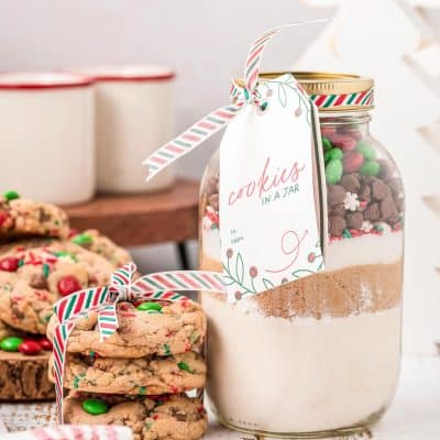 A jar of cookie mix with a stack of cookies next to it.