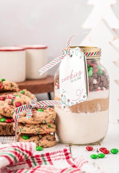 A jar of cookie mix with a stack of cookies next to it.