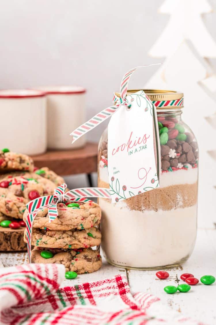 A jar of cookie mix with a stack of cookies next to it.