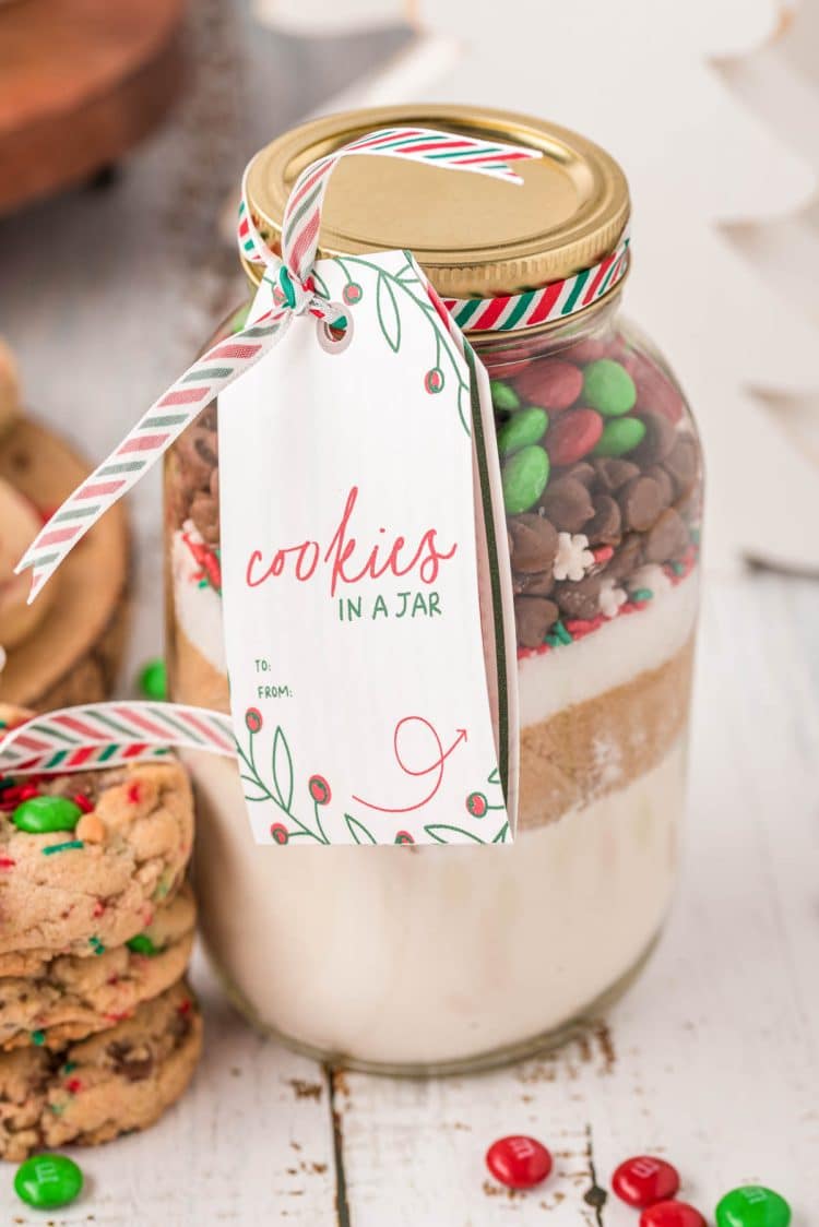 Cookies in a jar mix on a white wood table.