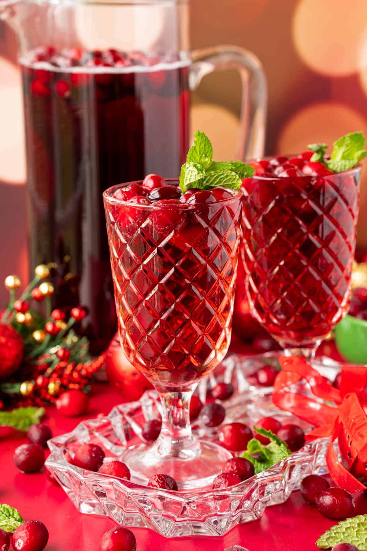 Two glasses of jingle juice on a glass tray with a pitcher behind them.