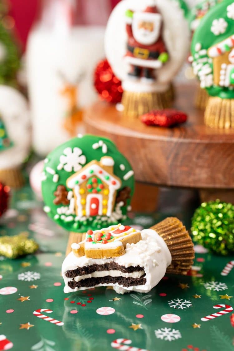 Oreo Snow Globe Cookies, one on it's side with a bite taken out of it.