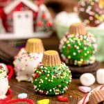 Oreo Ball Ornaments on a wooden table surrounded but holiday decorations.