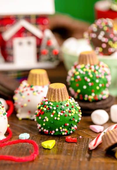 Oreo Ball Ornaments on a wooden table surrounded but holiday decorations.