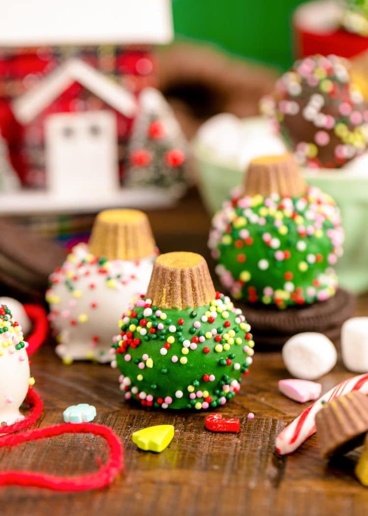 Oreo Ball Ornaments on a wooden table surrounded but holiday decorations.