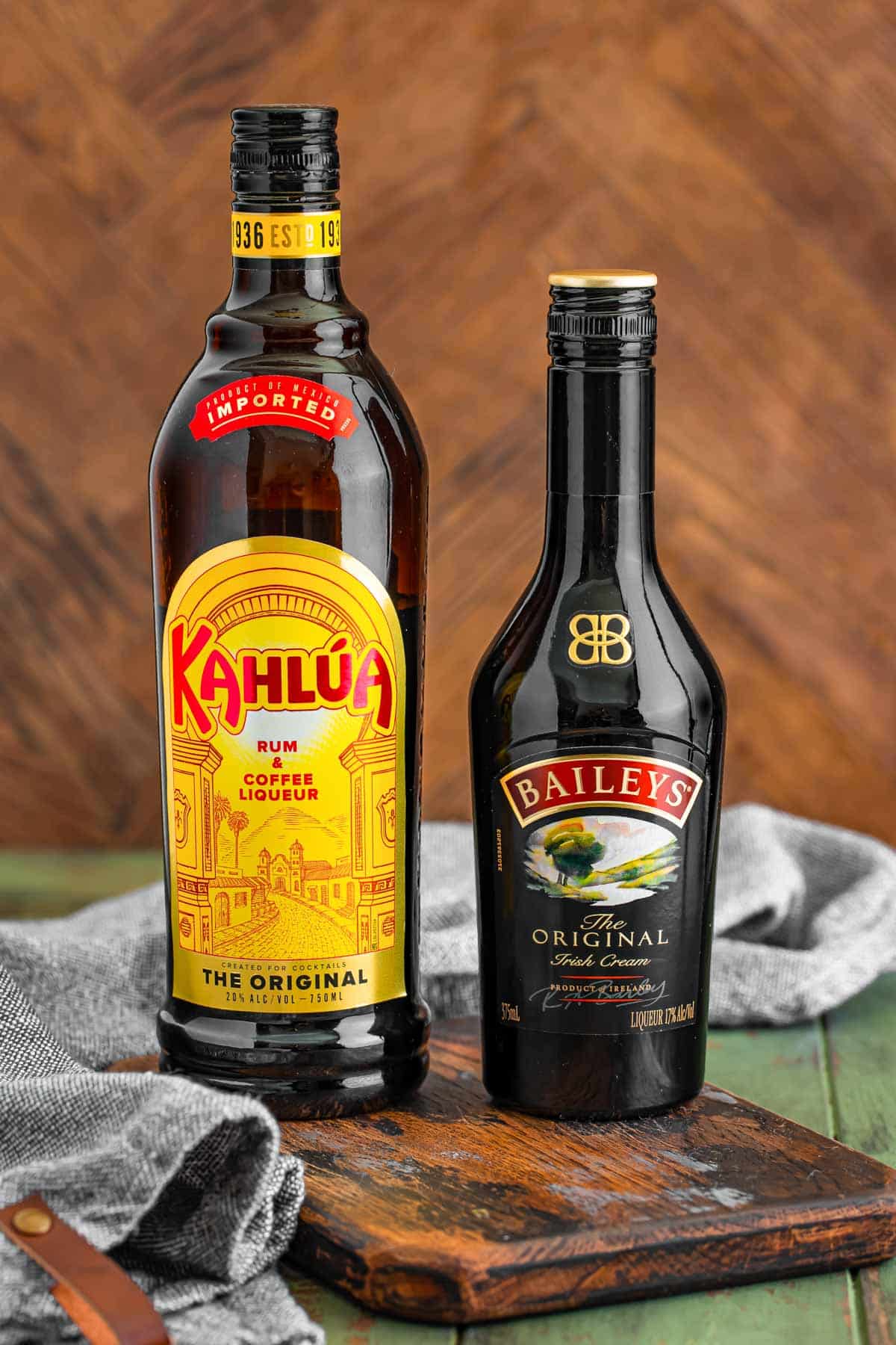 Bottles of Kahlua and Bailey's on a wooden serving board.