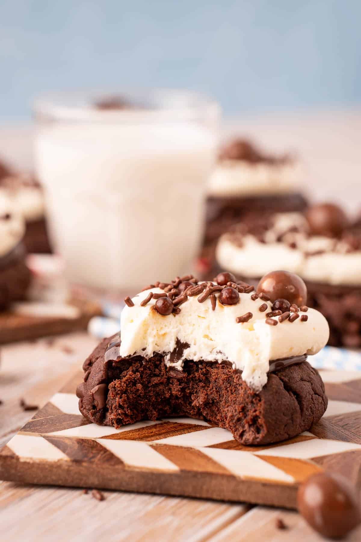 Close up of a chocolate milkshake cookie with a bite taken out of it.