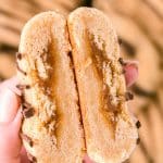 A woman's hand holding a churro cookie that's been cut in half.