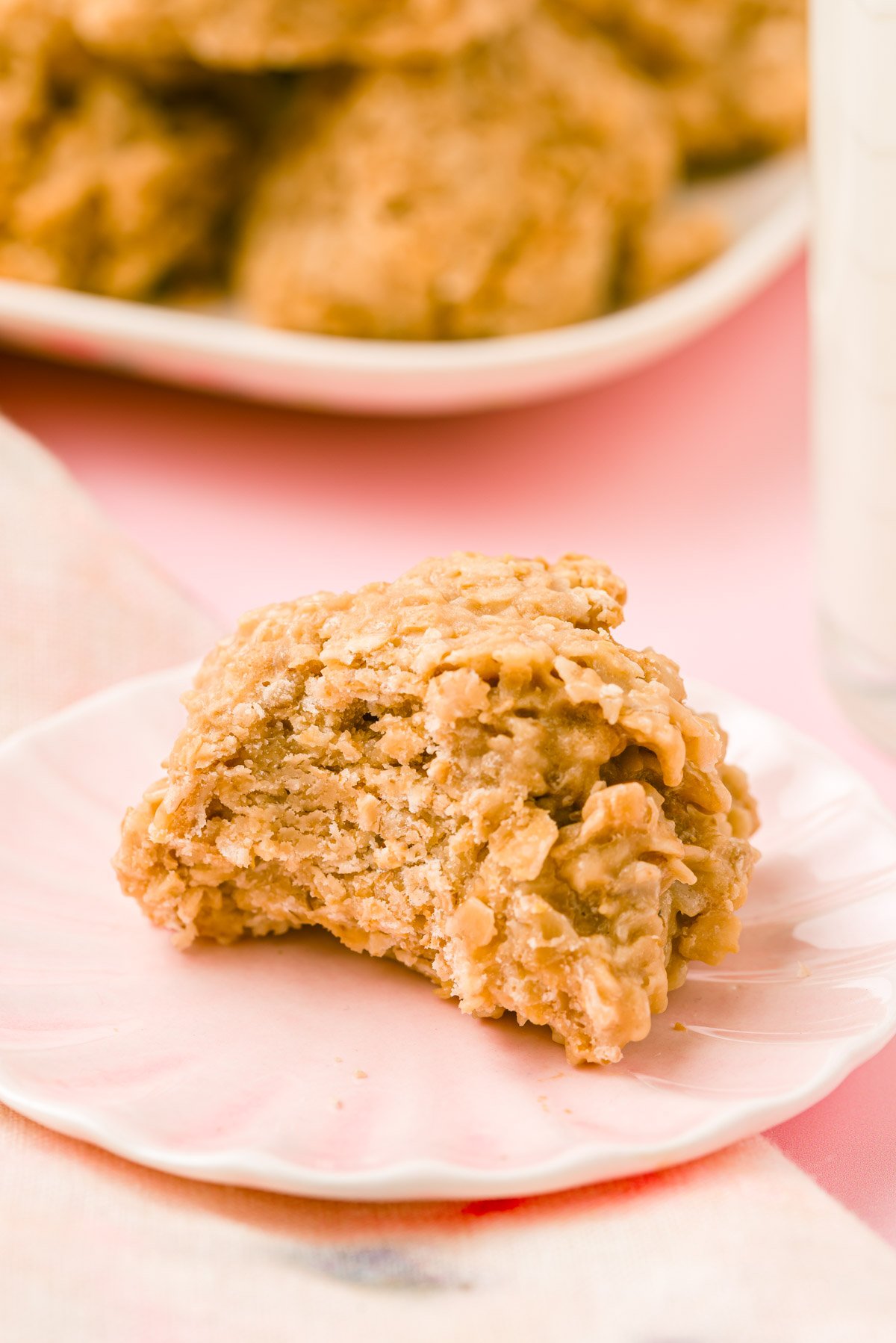 A cookie butter no bake cookie on a pink plate with a bite taken out of it.