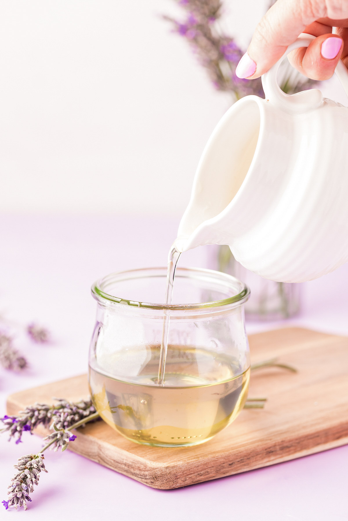 Lavender simple syrup being poured into a jar.