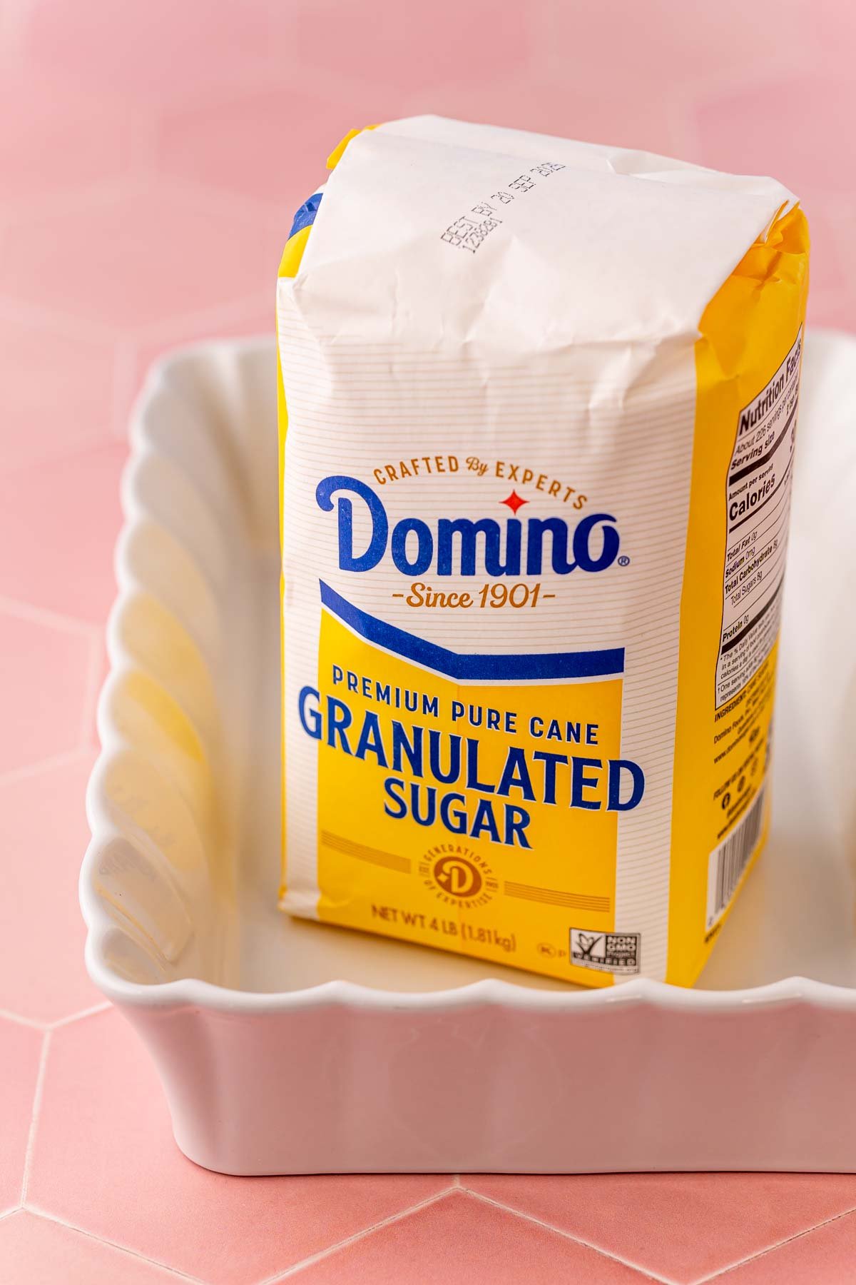 A bag of domino sugar in a white baking dish.