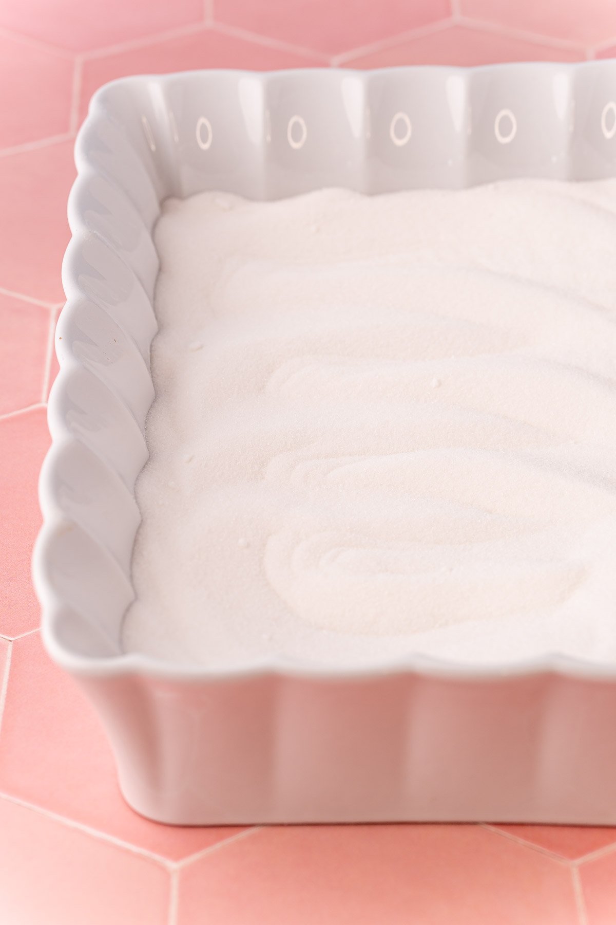 Sugar in a white ceramic baking dish.