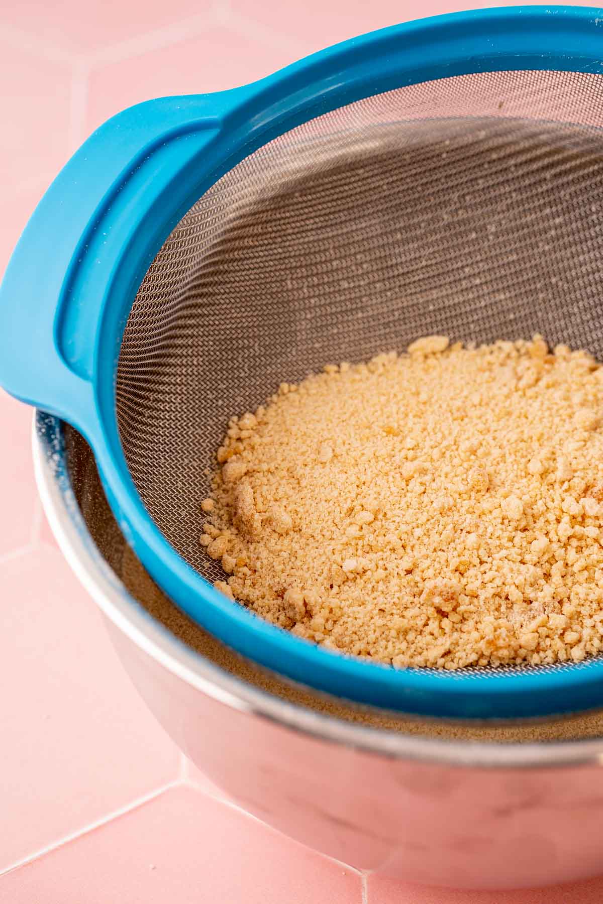 Toasted sugar being sifted into a bowl.
