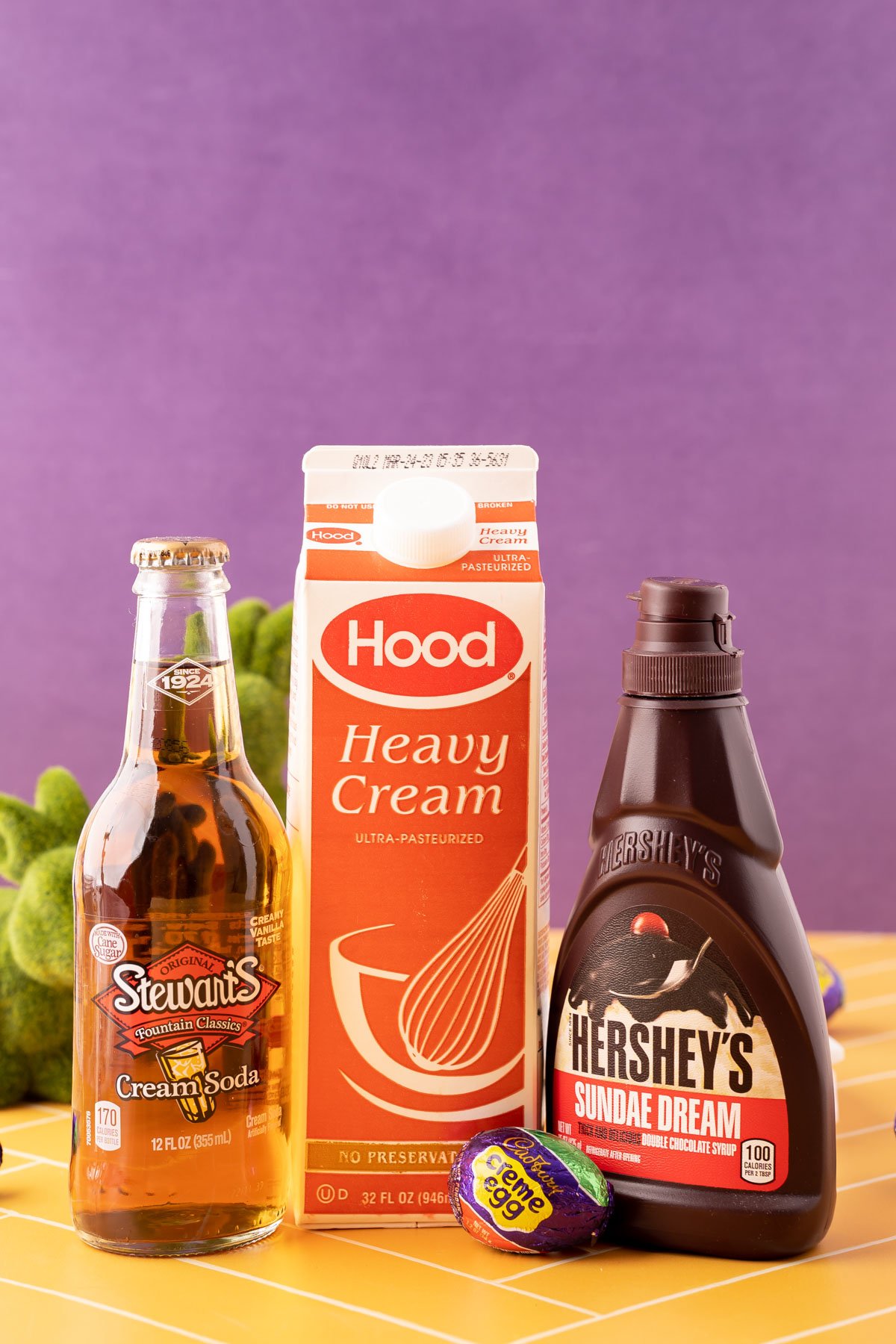 Ingredients to make Cadbury Creme Egg Dirty Soda on a yellow table.