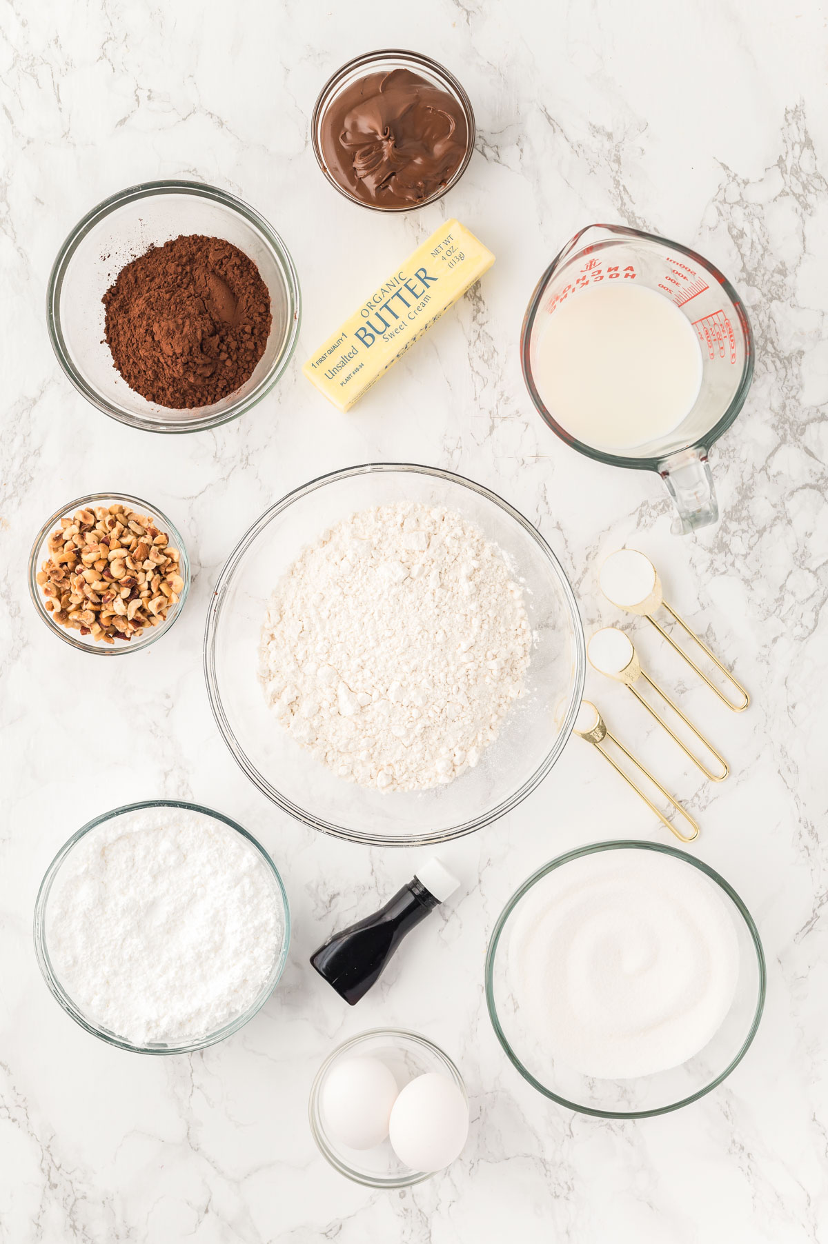 Ingredients to make Nutella Cupcakes on a marble counter.