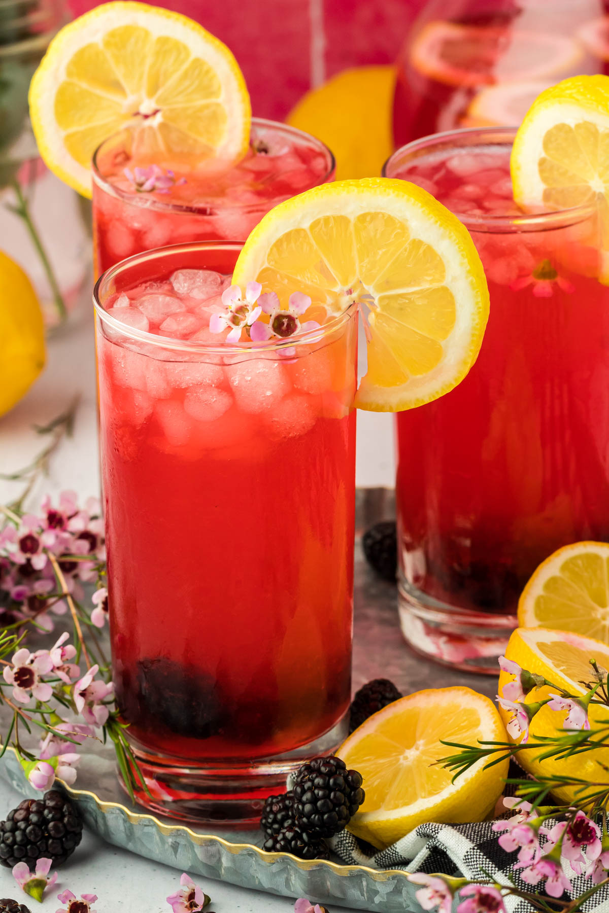 Glasses of blackberry lemonade on a table.