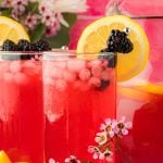 Glasses of blackberry lemonade on a table.