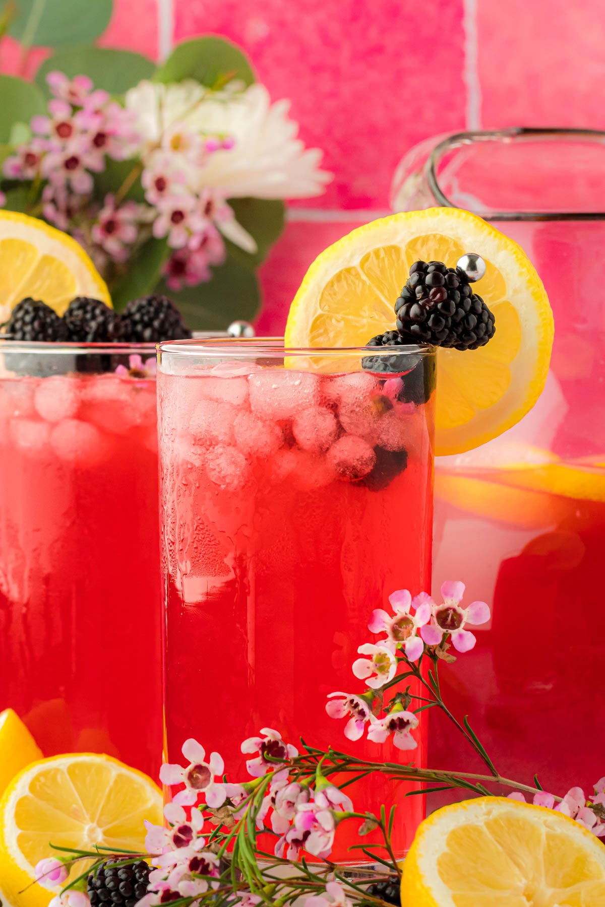 Glasses of blackberry lemonade on a table.