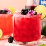 Two Blackberry Margaritas on a table.