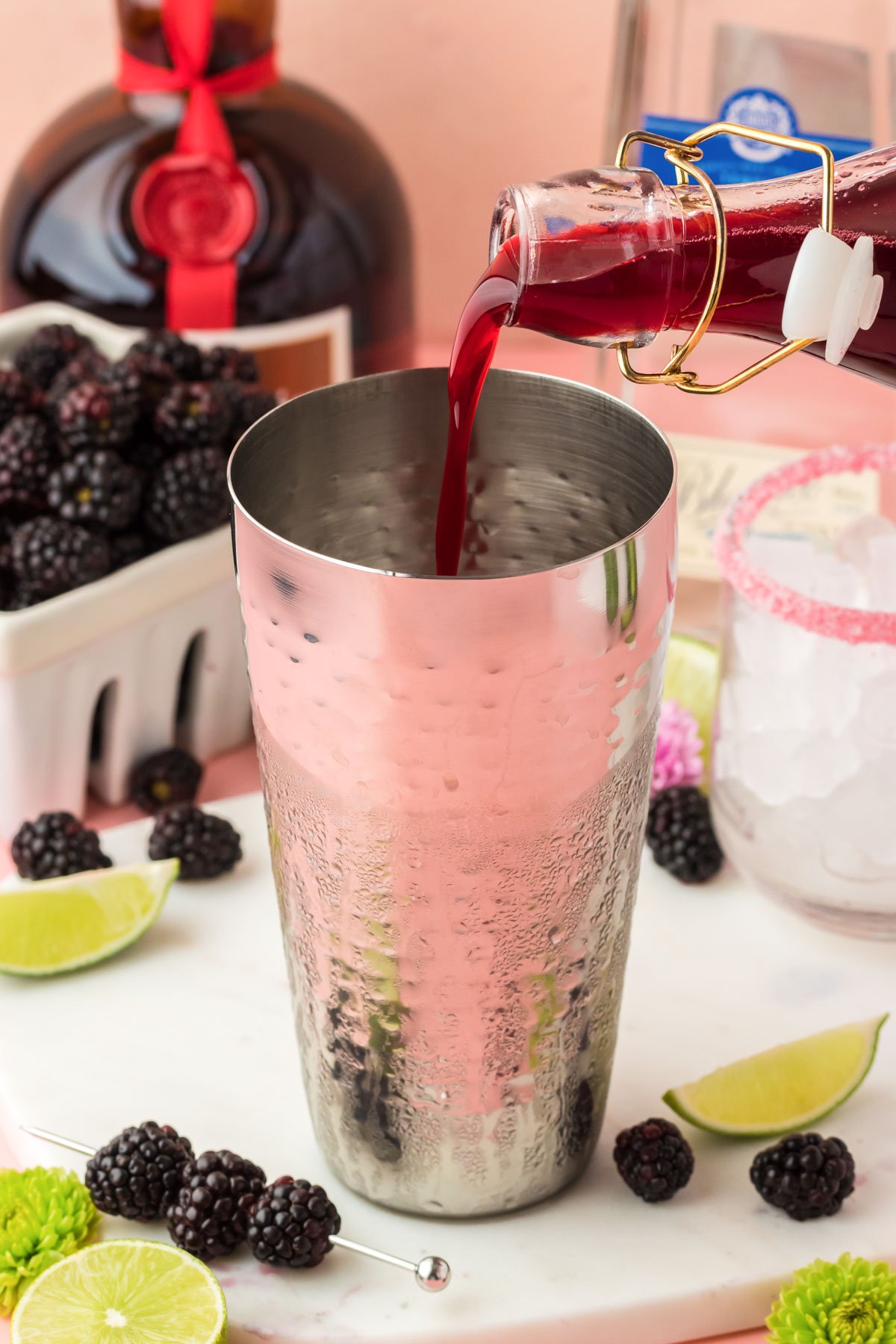 Blackberry simple syrup being poured into a cocktail shaker.