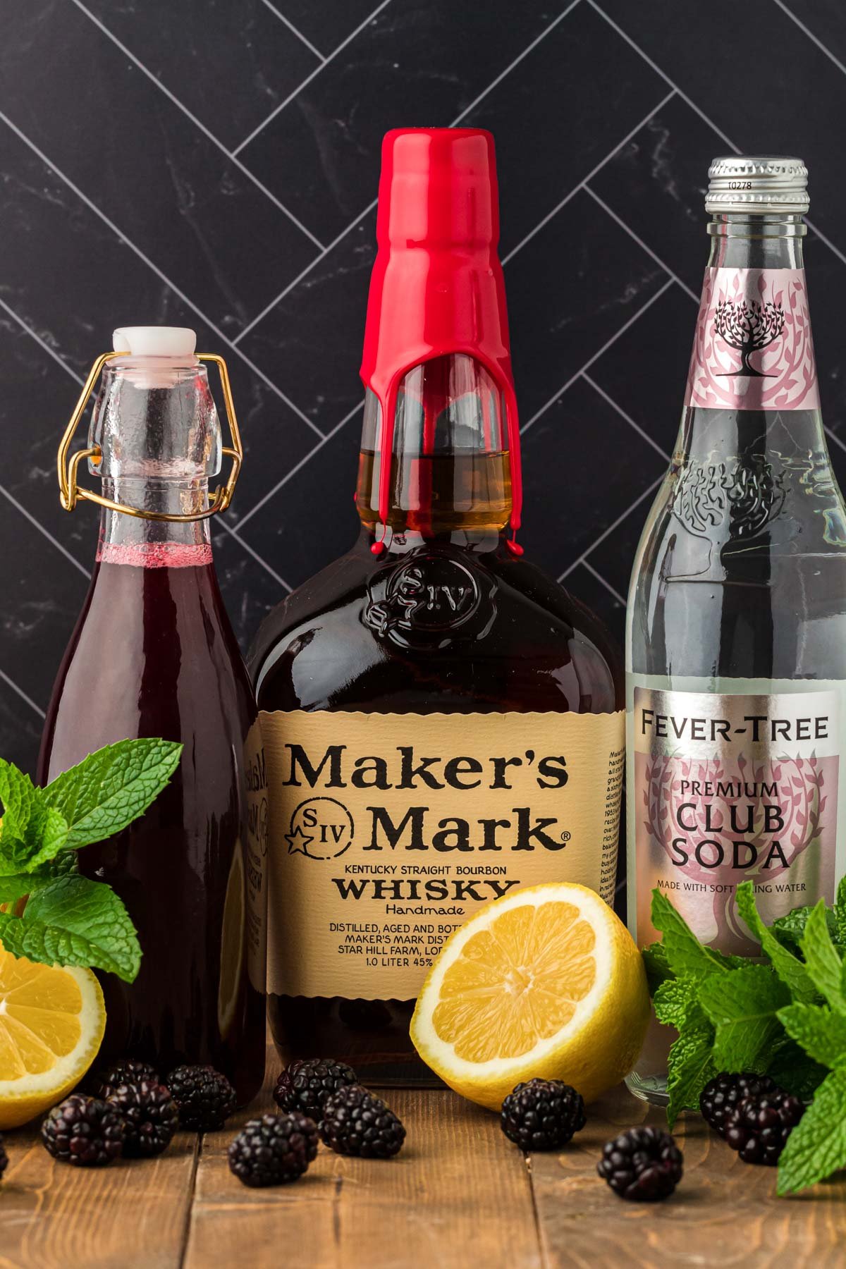 Ingredients to make a bourbon smash (blackberry) on a wooden table.