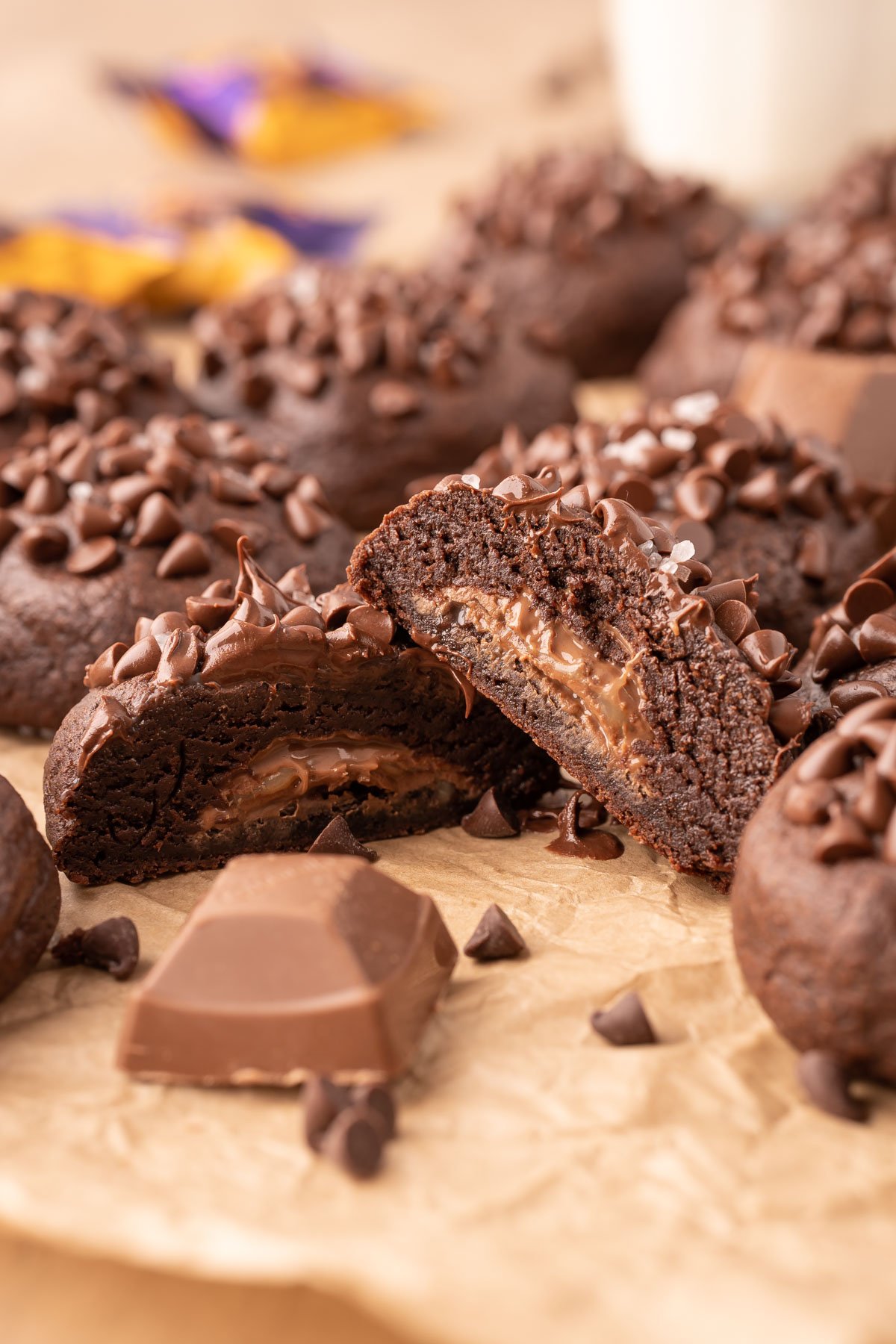 A chocolate cookie stuffed with a caramel candy sliced in half to show the inside.