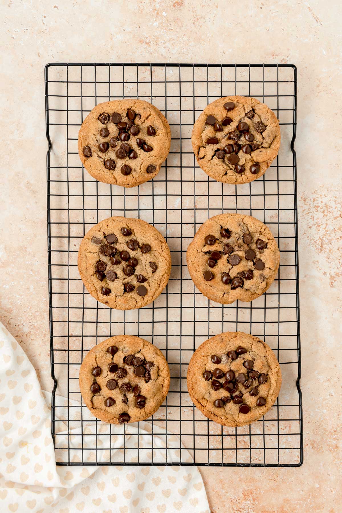 Cinnamon chocolate chip cookies on a black wire rack on a table.