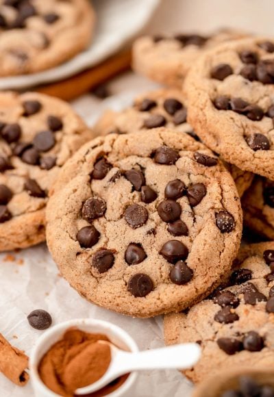 Close up of chocolate chip cookies with cinnamon sugar coating in a pile on a table.