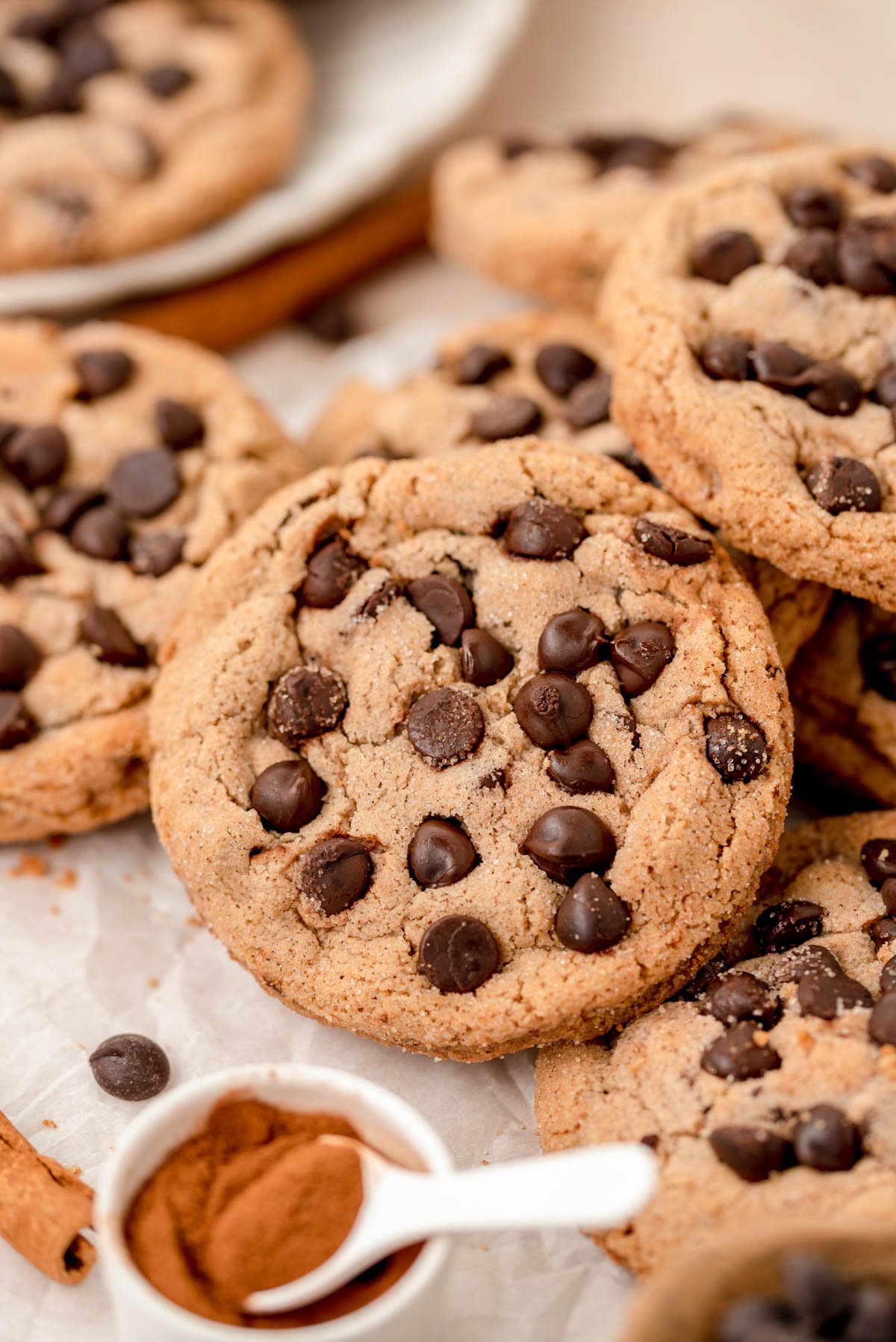 Close up of chocolate chip cookies with cinnamon sugar coating in a pile on a table.