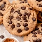 Close up of chocolate chip cookies with cinnamon sugar coating in a pile on a table.