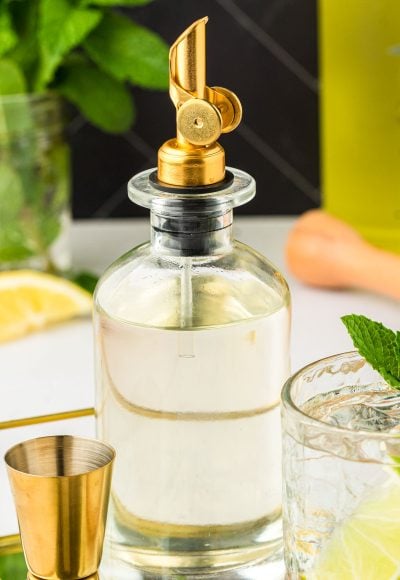 A bottle of homemade simple syrup on a bar.