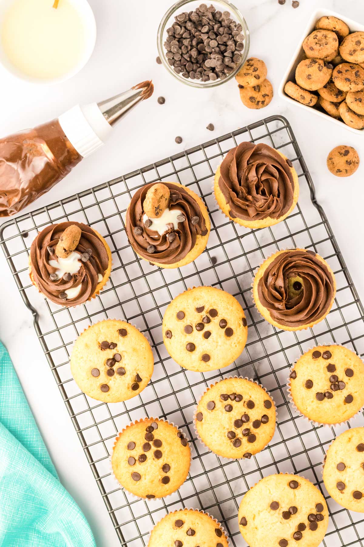 Chocolate frosting being piped onto chocolate chip cupcakes.