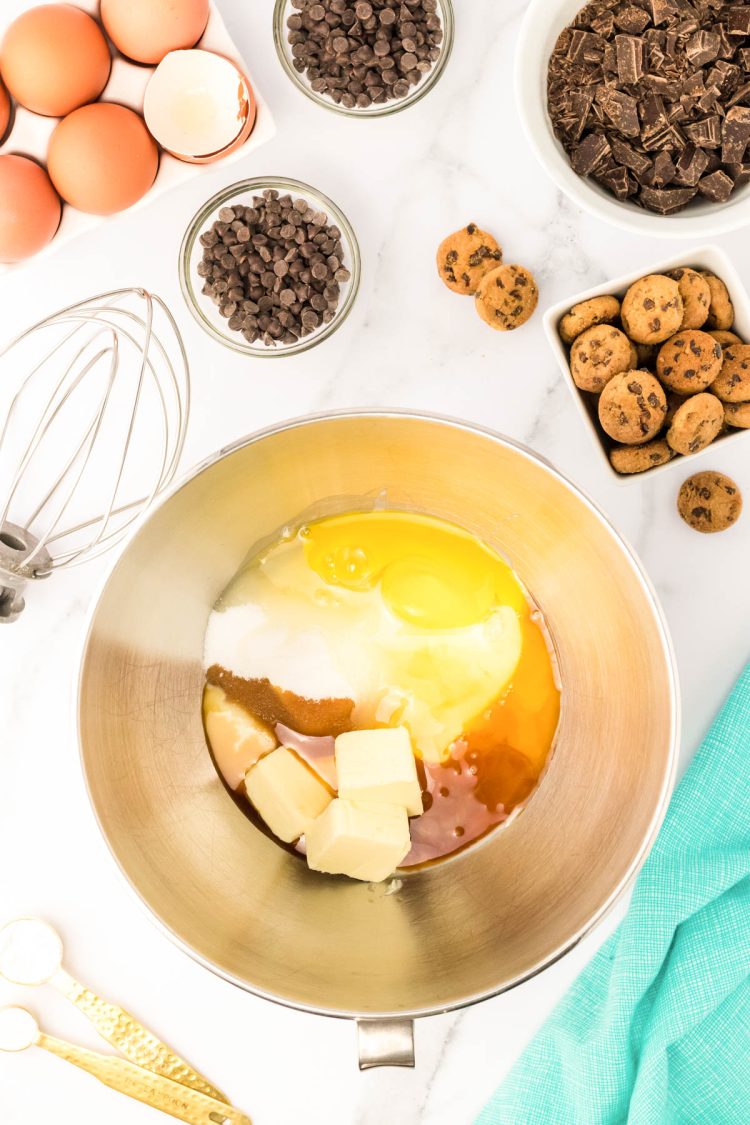 butter, sweetened condensed milk, vanilla, and eggs in a stand mixer ready to be mixed.