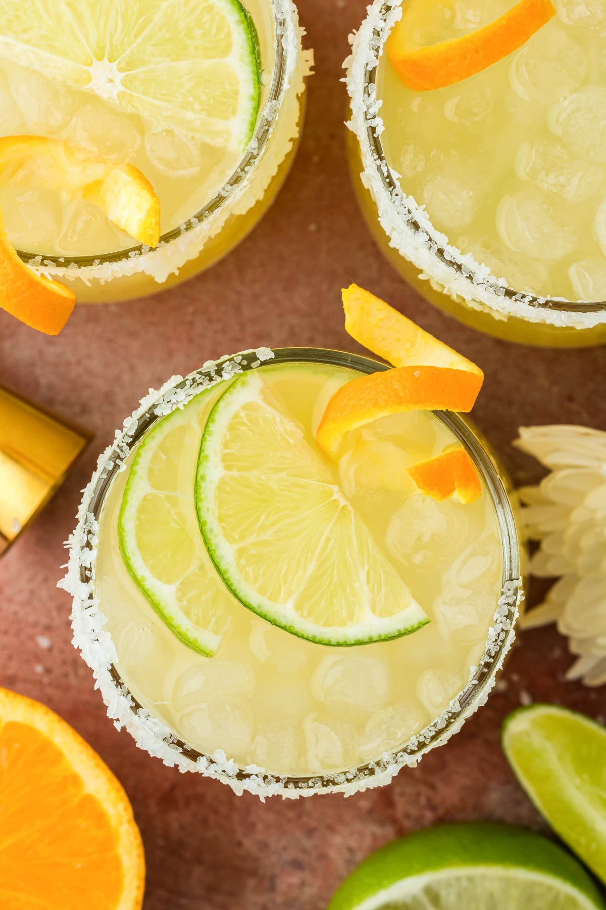 Overhead photo of glasses filled with skinny margaritas and garnished with citrus.