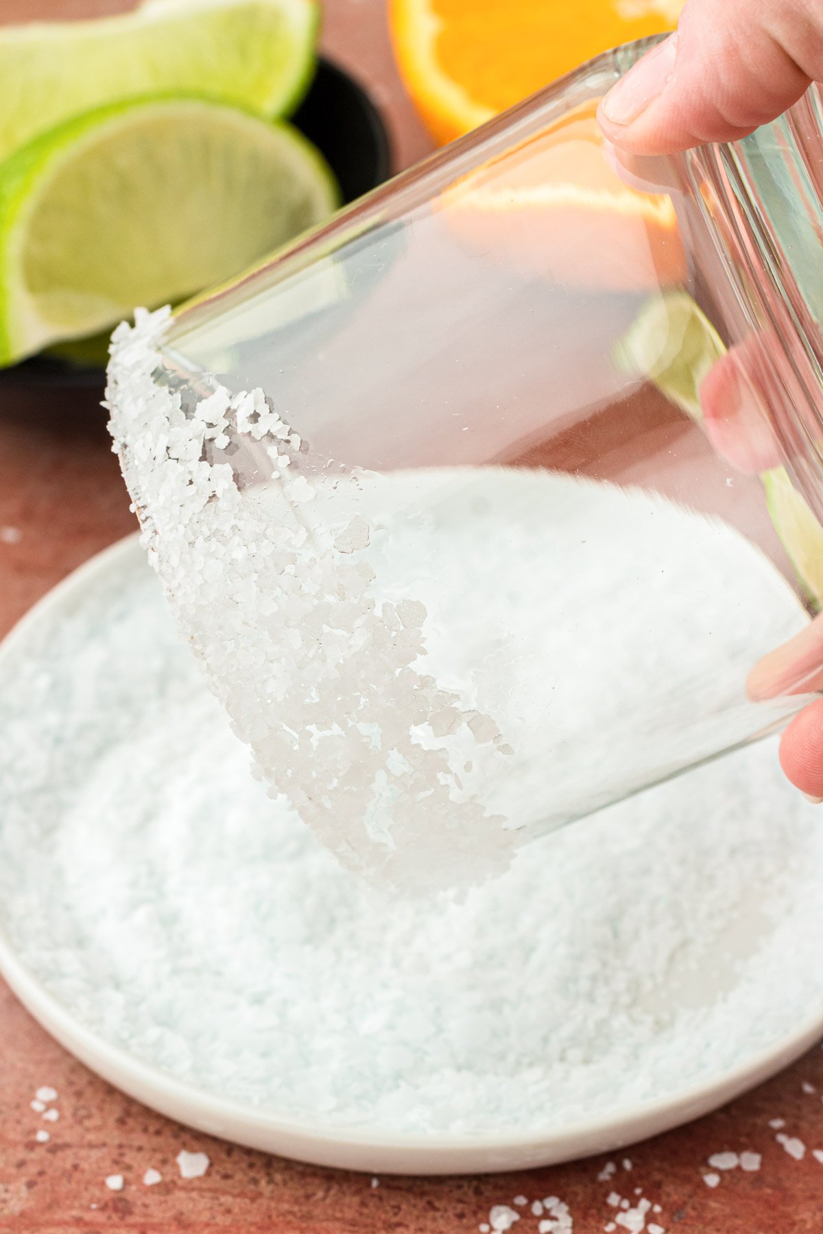 A glass being dipped in coarse salt to line the rim.