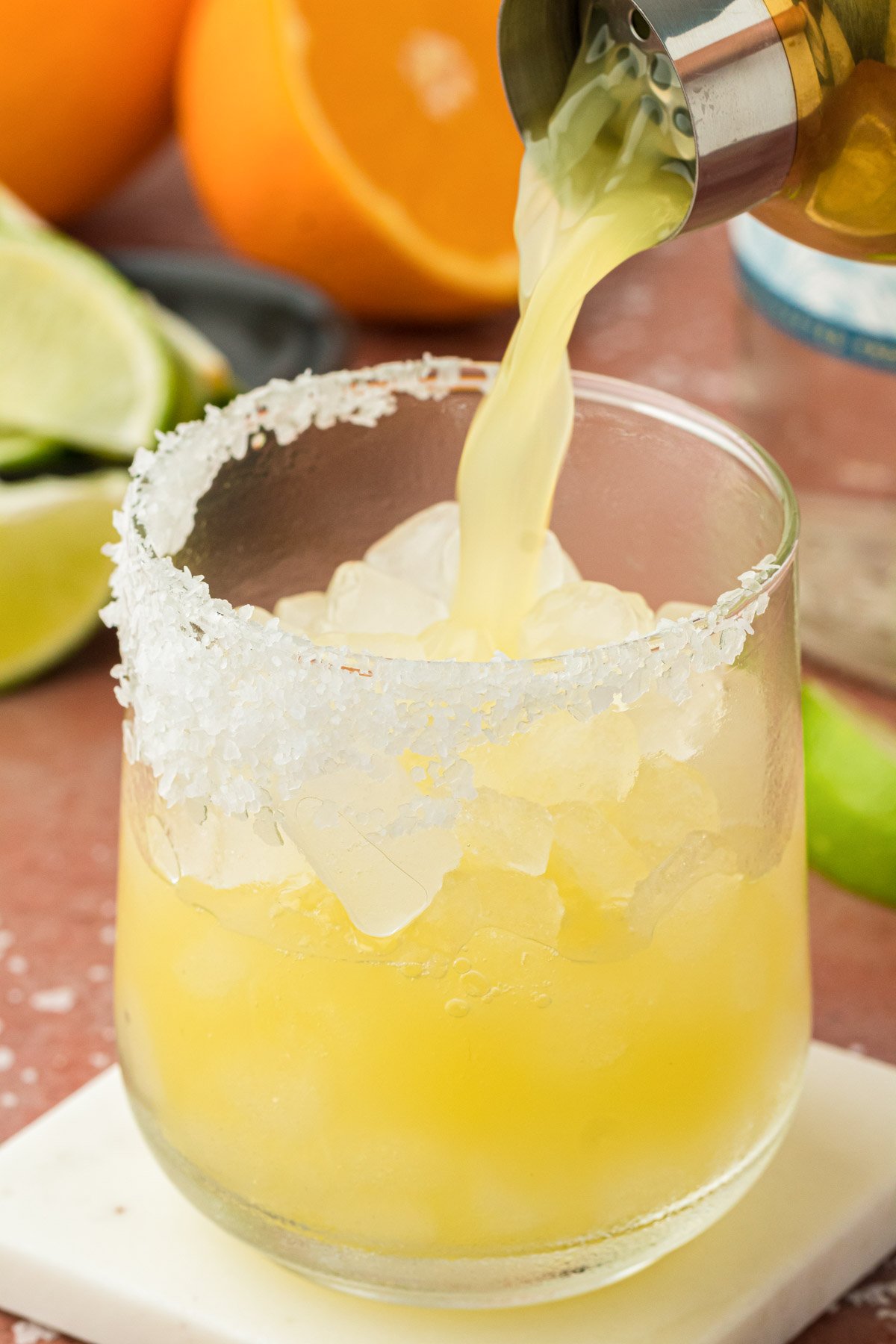 A skinny margarita being strained into a glass from a cocktail shaker.
