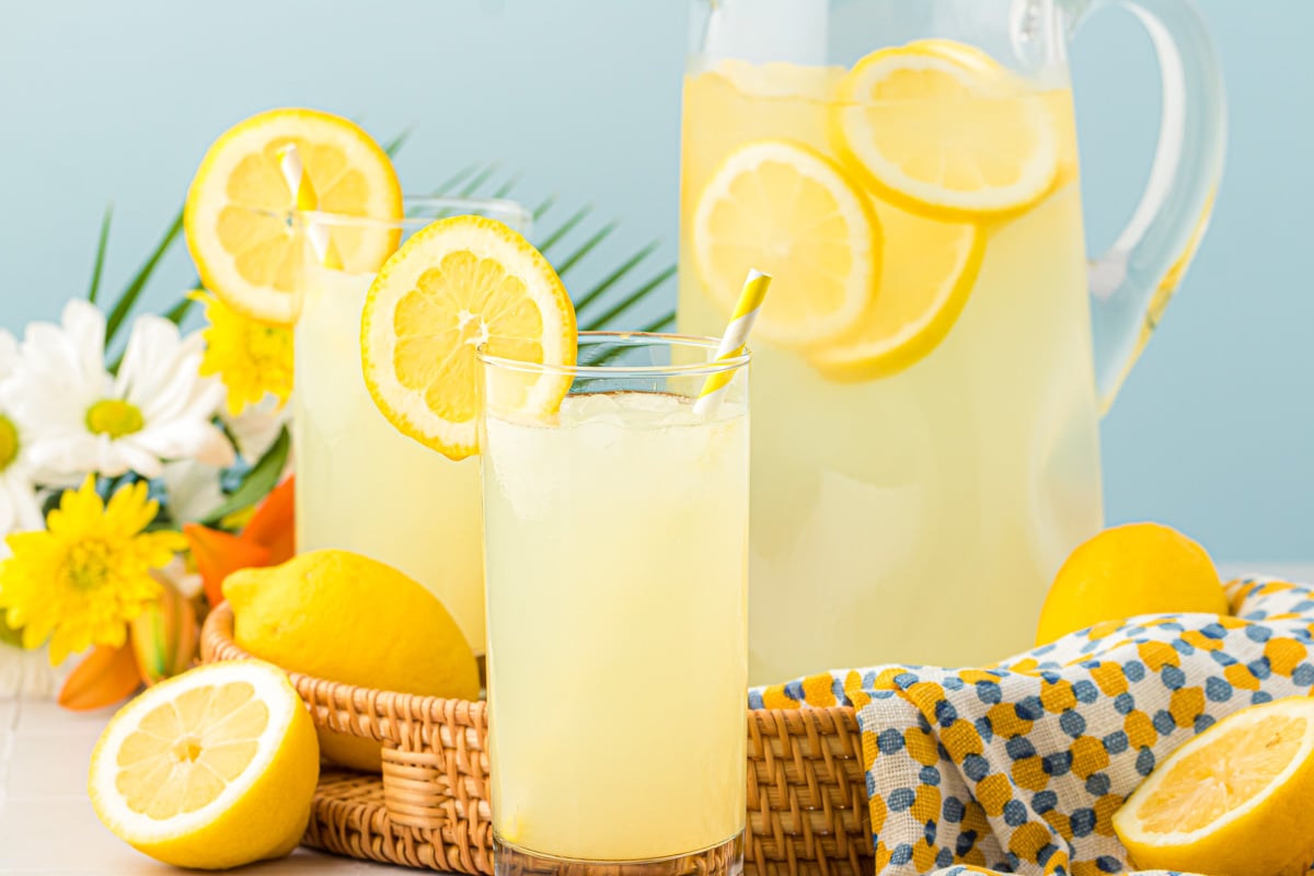 Glasses of lemonade sitting next to a pitcher.