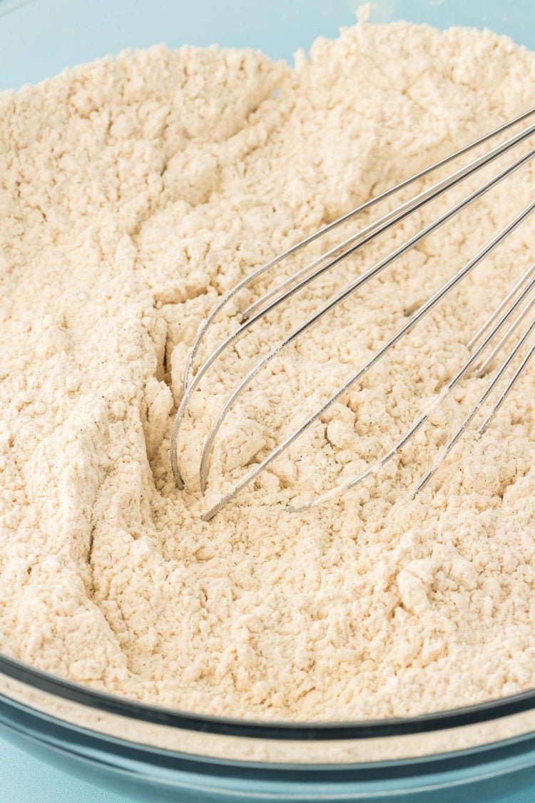 Flour and pudding mix being whisked together in a bowl.
