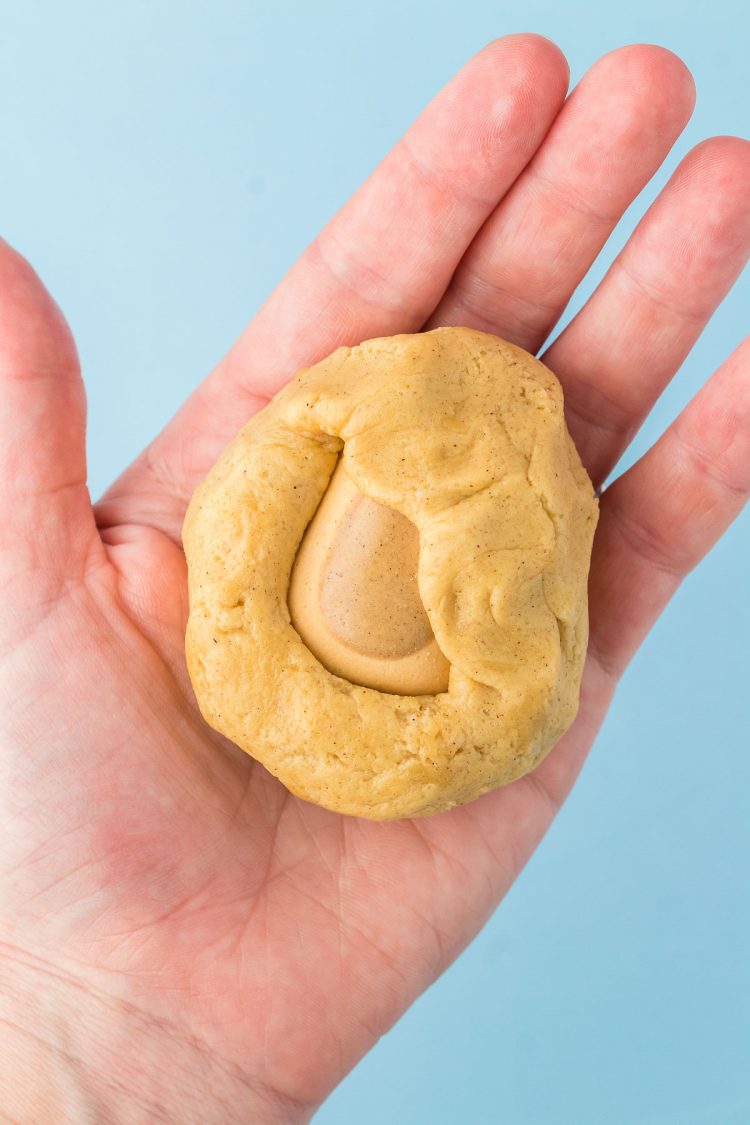 A brown sugar pop tart bite being wrapped in cookie dough.