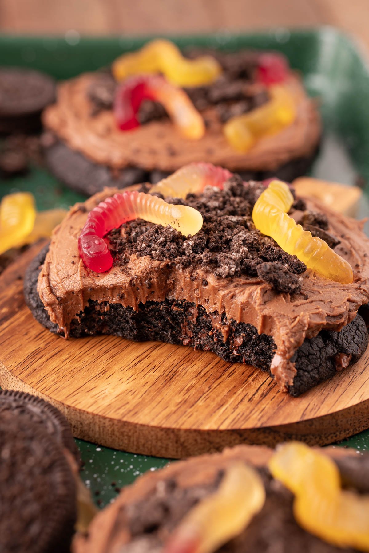 Dirt Cake Cookie on a wooden plate with bites taken out of it to show the texture inside.