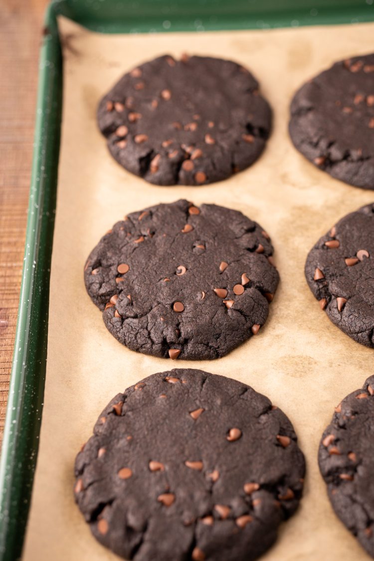 Black cocoa cookies on a parchment lined baking sheet.