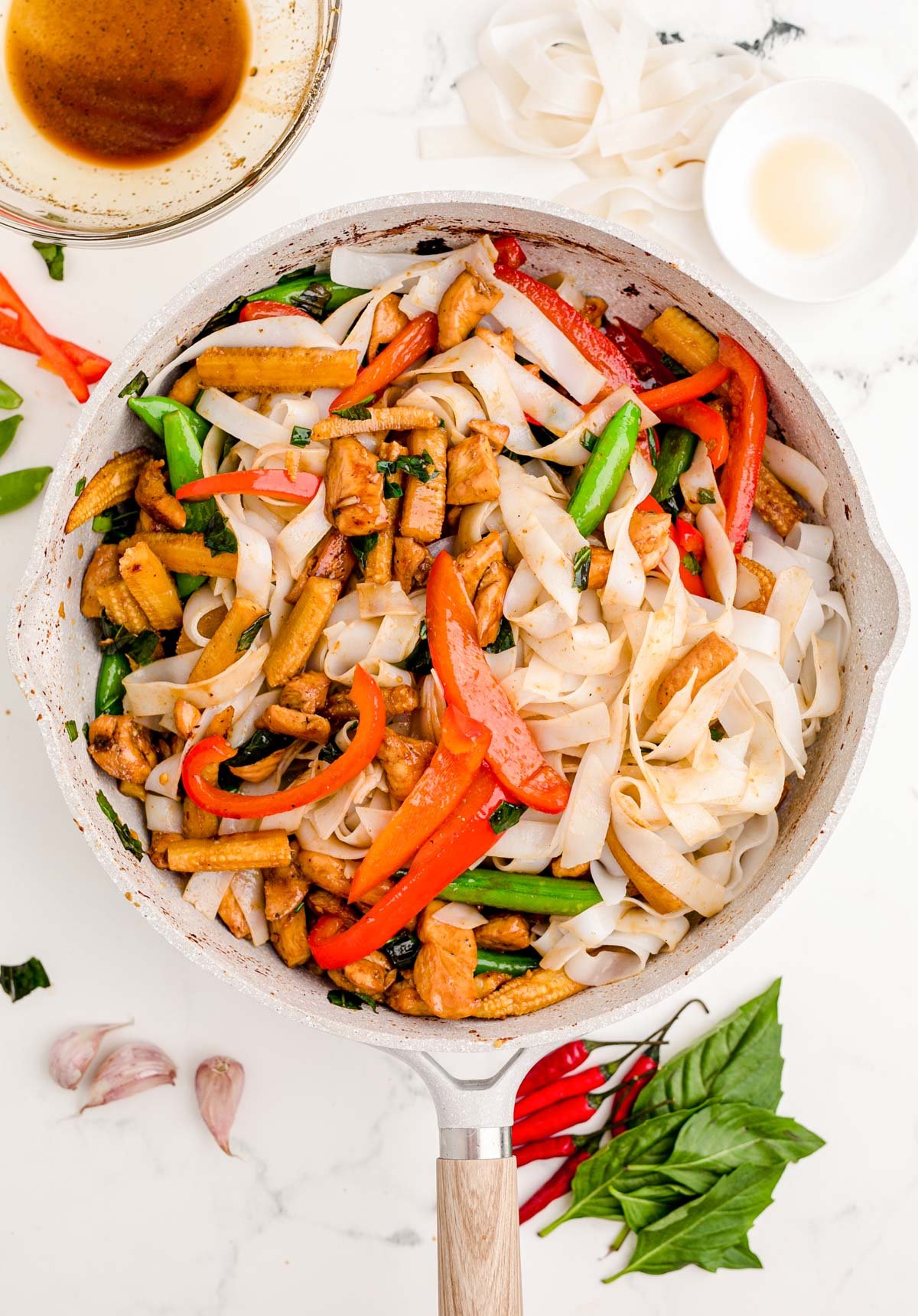 Drunken noodles being made in a skillet.