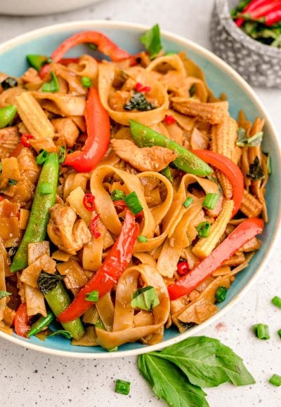 A blue bowl filled with drunken noodles.