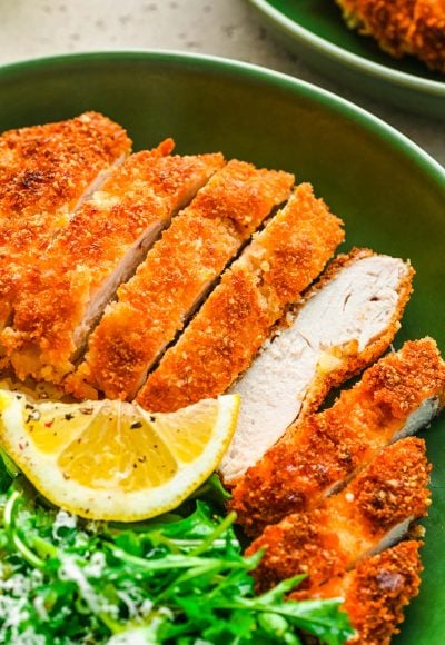 Overhead photo of panko chicken in a green bowl with rice and greens.