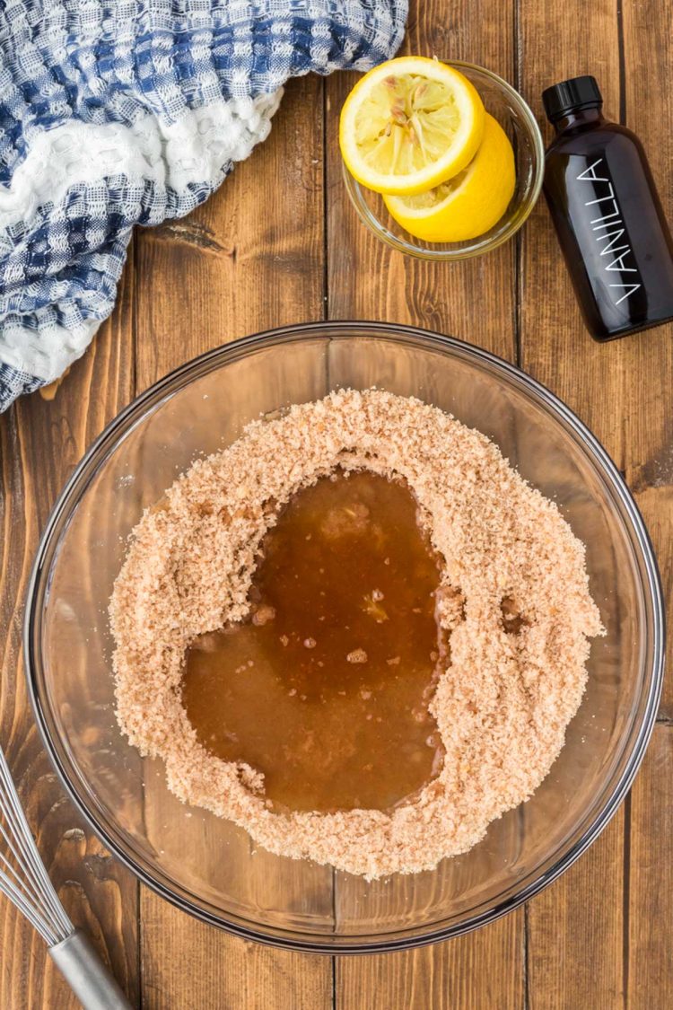 Butter, vanilla, and lemon juice being added to a bowl of sugar and flour.