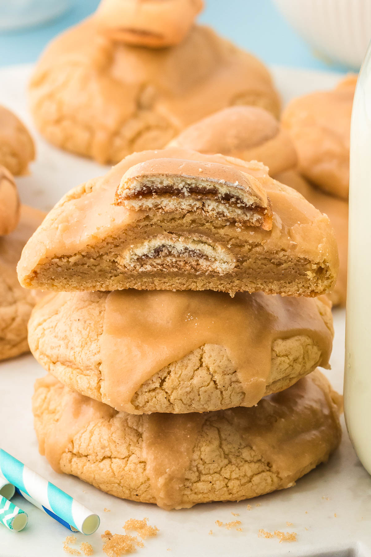 A stack of three brown sugar pop tart cookies, the top one is sliced in half to show the inside.