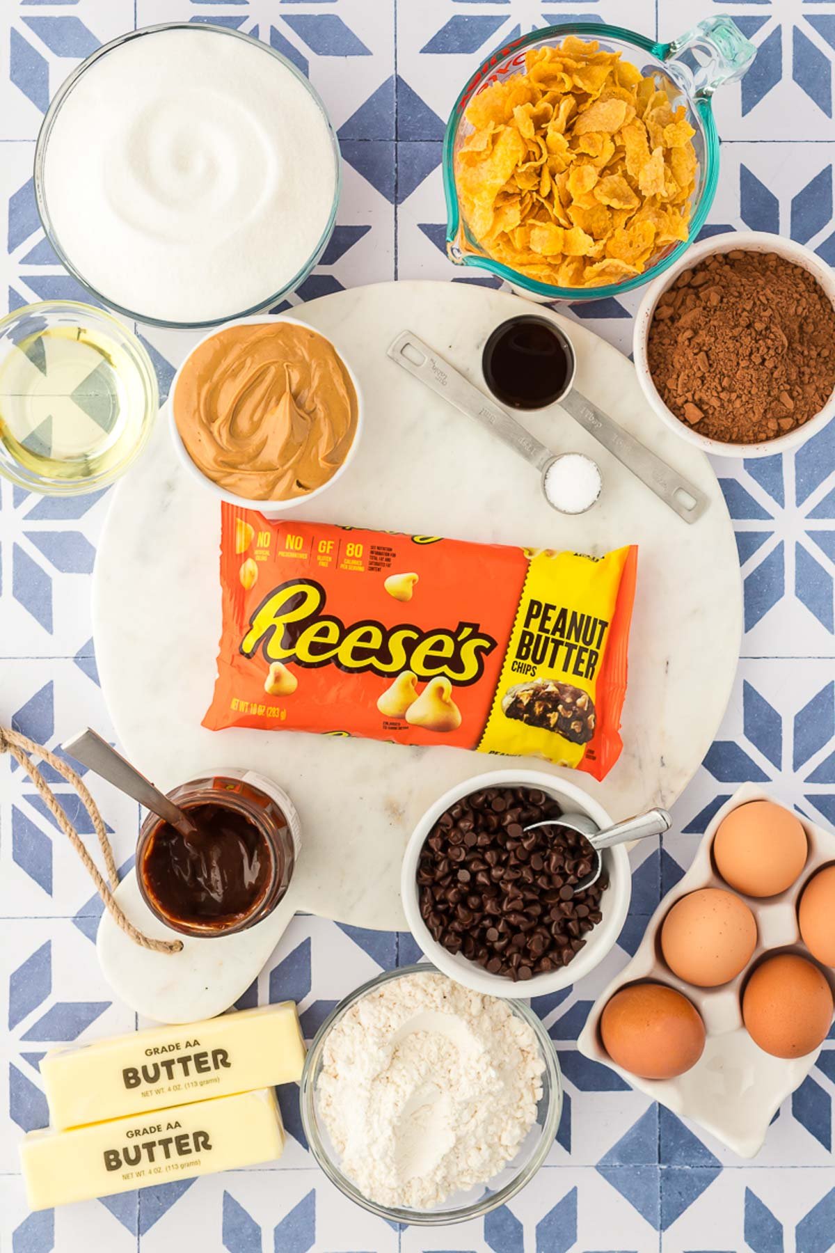 Ingredients to make peanut butter crunch brownies on a blue and white mosaic table.