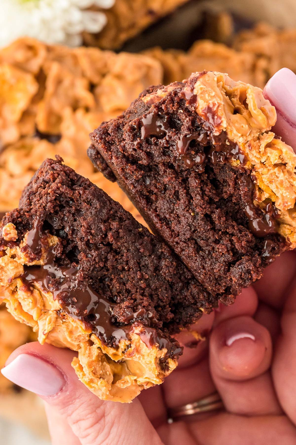 A woman's hand breaking apart a peanut butter crunch brownie.