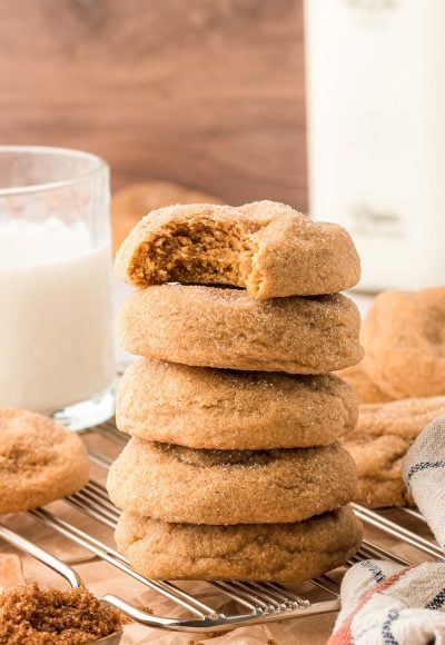 A stack of five brown sugar cookies, the top one is missing a bite.