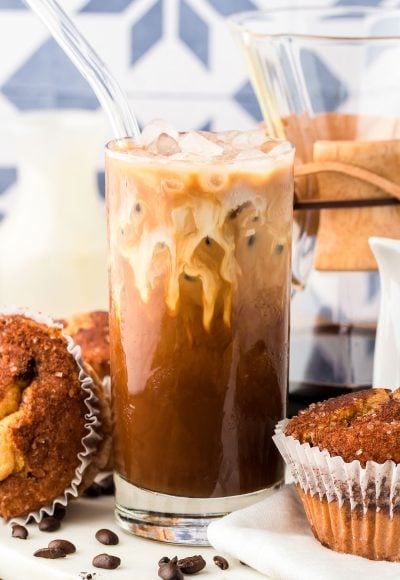 A glass filled with Thai iced coffee on a white table.